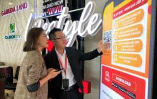 Nhân viên tư vấn đang hướng dẫn khách hảng tải ứng dụng GL Lifestyle. Ảnh: Gamuda Land.